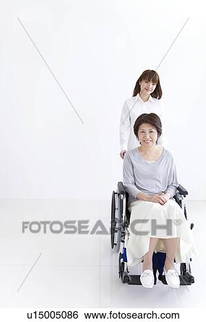 Daughter caring for her mother in a wheelchair View Large Photo Image Stock Photograph - Daughter caring for her mother in a wheelchair. Fotosearch