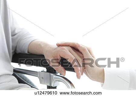 Daughter holding the hand of her mother in a wheelchair View Large Photo Image Stock Image - Daughter holding the hand of her mother in a wheelchair. Fotosearch