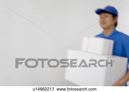 Delivery man carrying package View Large Photo Image Stock Photo - Delivery man carrying package. Fotosearch