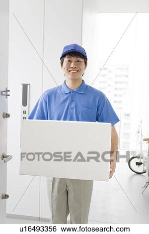 Delivery man carrying package View Large Photo Image Stock Photograph - Delivery man carrying package. Fotosearch