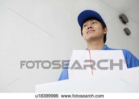 Stock Photograph - Delivery man carrying package. Fotosearch