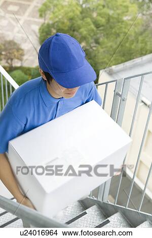 Delivery man carrying package up stairs View Large Photo Image Picture - Delivery man carrying package up stairs. Fotosearch
