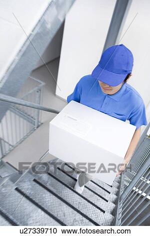 Delivery man carrying package up stairs View Large Photo Image Stock Image - Delivery man carrying package up stairs. Fotosearch