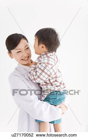Stock Image - Doctor holding young boy. Fotosearch