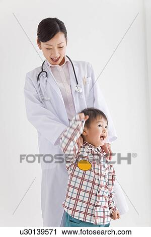 Stock Image - Doctor holding young boy. Fotosearch