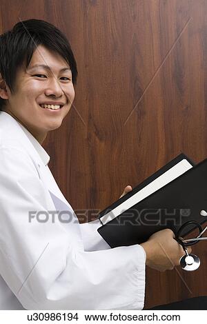 Doctor reading documents View Large Photo Image Picture - Doctor reading documents. Fotosearch