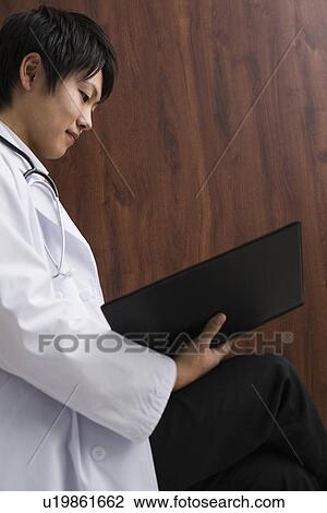 Doctor reading documents View Large Photo Image Stock Image - Doctor reading documents. Fotosearch