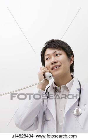 Picture - Doctor talking on the telephone. Fotosearch