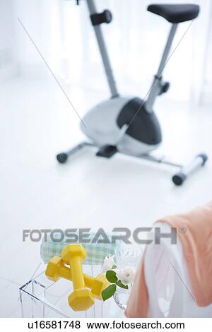 Stock Photo - Dumbbells and an exercise bike. Fotosearch