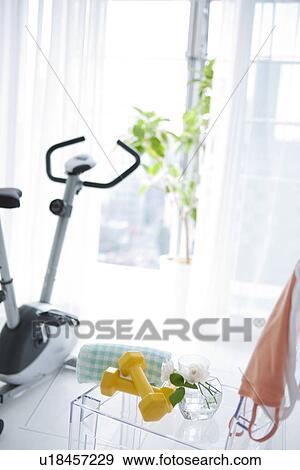 Stock Photo - Dumbbells and an exercise bike. Fotosearch