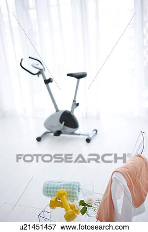 Stock Photo - Dumbbells and an exercise bike. Fotosearch