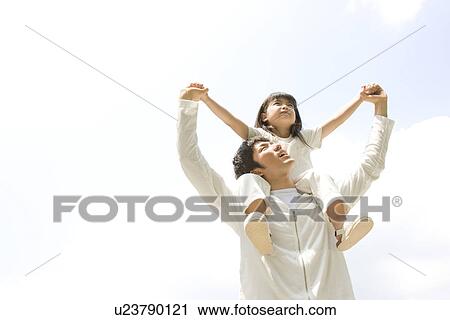 Stock Image - Father giving daughter a shoulder ride. Fotosearch