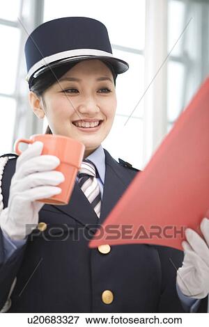 Female guard reading a document and holding a coffee cup View Large Photo Image Stock Photo - Female guard reading a document and holding a coffee cup. Fotosearch