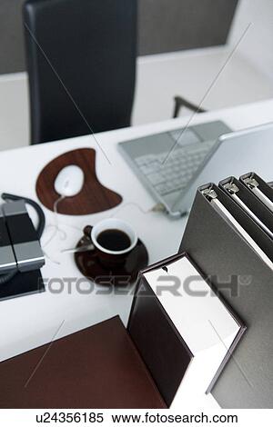 Stock Photography - Files and book on office desk with coffee cup. Fotosearch