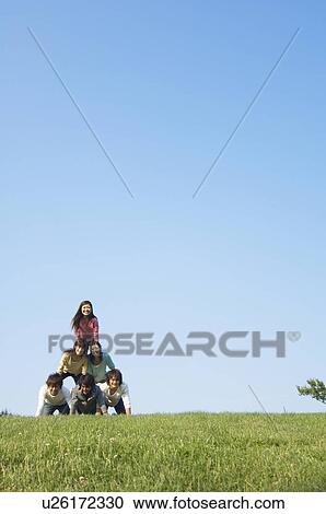 Five people making human pyramid View Large Photo Image Stock Image - Five people making human pyramid. Fotosearch