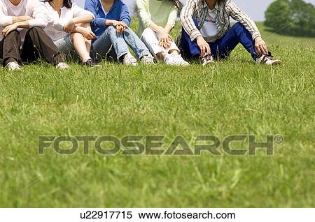 Stock Photography - Five people sitting on grass. Fotosearch