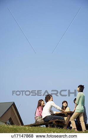Five people sitting together at picnic table View Large Photo Image Stock Photo - Five people sitting together at picnic table. Fotosearch