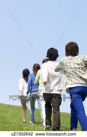 Five young people walking on grass View Large Photo Image Stock Image - Five young people walking on grass. Fotosearch