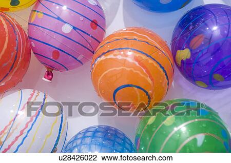 Stock Image - Floating balls and balloons in a paddling pool. Fotosearch