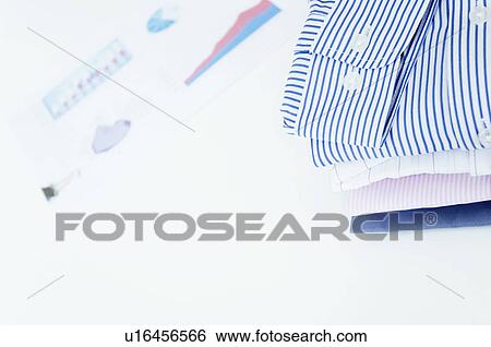 Folded business shirts next to paperwork View Large Photo Image Stock Photograph - Folded business shirts next to paperwork. Fotosearch