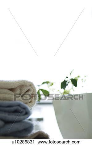 Stock Image - Folded towels and a potted plant. Fotosearch