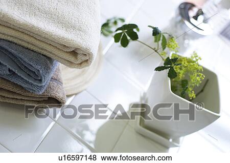 Stock Photo - Folded towels and a potted plant. Fotosearch