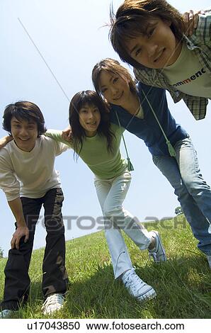 Four young people with arms around each other View Large Photo Image Stock Image - Four young people with arms around each other. Fotosearch
