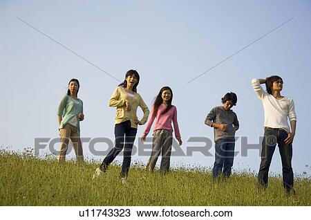 Stock Image - Friends playing around in a field. Fotosearch