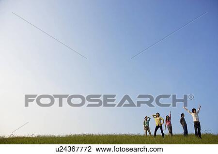 Friends playing around in a field View Large Photo Image Stock Image - Friends playing around in a field. Fotosearch