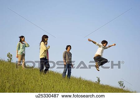Stock Photo - Friends playing around in a field. Fotosearch