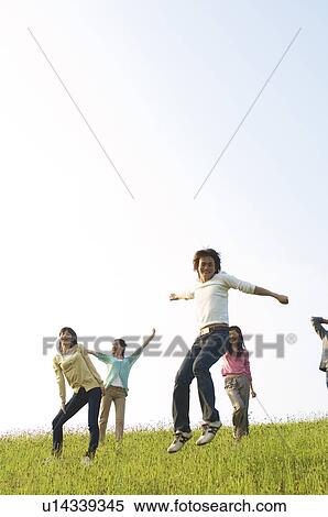 Stock Photography - Friends playing around in a field. Fotosearch