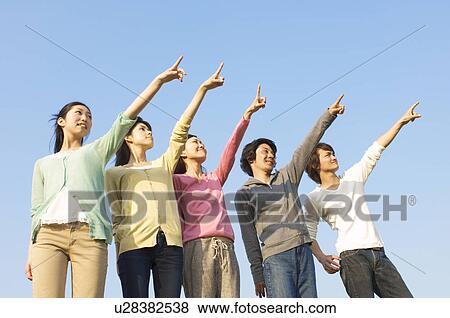 Stock Photo - Friends pointing towards the sky. Fotosearch