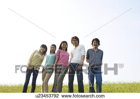 Friends standing in a field View Large Photo Image Stock Image - Friends standing in a field. Fotosearch