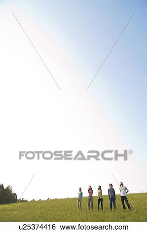 Friends standing side by side in a field View Large Photo Image Stock Photograph - Friends standing side by side in a field. Fotosearch