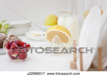 Stock Photo - Fruit and a juicer on a kitchen counter. Fotosearch