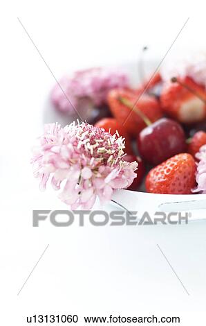 Stock Image - Fruit served in a tray with flowers. Fotosearch