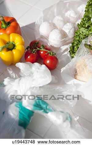 Stock Photo - Fruit, vegetables and eggs with plastic shopping bags. Fotosearch