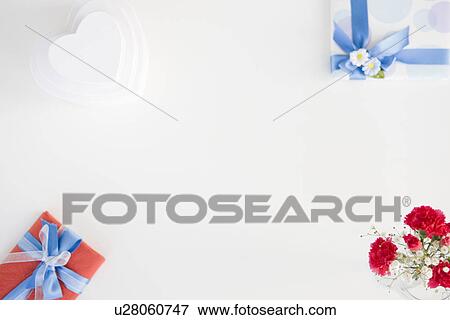 Stock Photo - Gift boxes and a vase of carnations and baby's breath. Fotosearch