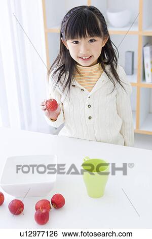 Stock Photograph - Girl holding an apple. Fotosearch