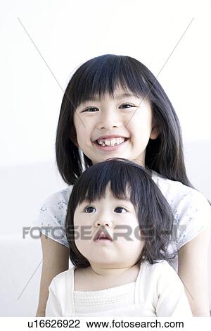 Stock Image - Girl holding her baby sister. Fotosearch