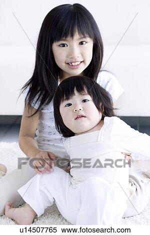 Girl holding her baby sister View Large Photo Image Stock Photography - Girl holding her baby sister. Fotosearch