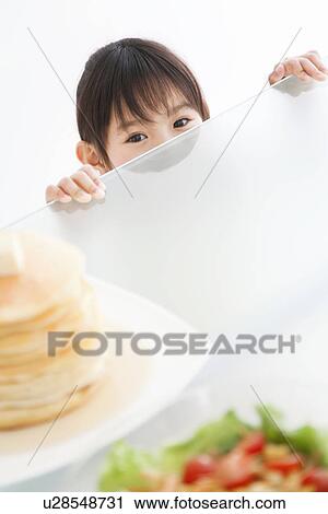 Girl peeking over the table at food View Large Photo Image Stock Image - Girl peeking over the table at food. Fotosearch