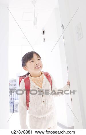 Stock Image - Girl standing in a doorway. Fotosearch