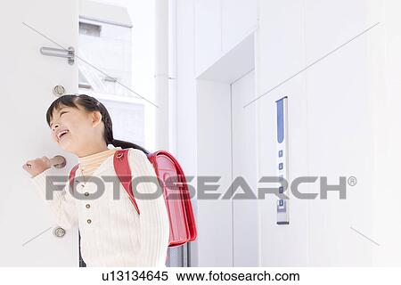 Girl standing in a doorway View Large Photo Image Stock Photography - Girl standing in a doorway. Fotosearch
