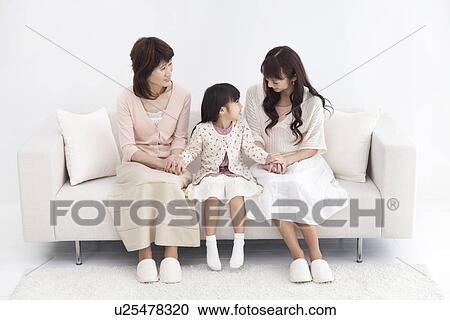 Girl with her mother and grandmother sitting on a sofa View Large Photo Image Stock Image - Girl with her mother and grandmother sitting on a sofa. Fotosearch