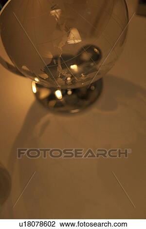 Stock Image - Glass globe on desk in office. Fotosearch