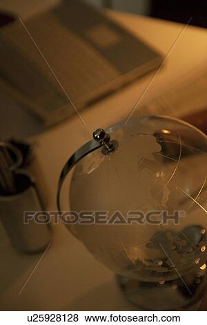 Glass globe on desk in office View Large Photo Image Stock Photo - Glass globe on desk in office. Fotosearch