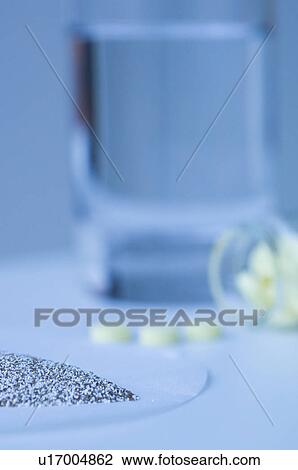Stock Image - Glass of water and powdered medicine. Fotosearch