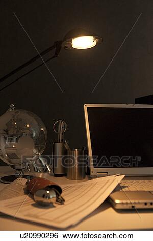 Stock Photograph - Glasses, documents and laptop on desk. Fotosearch