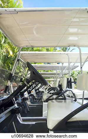Stock Photo - Golf carts lined up in a row. Fotosearch